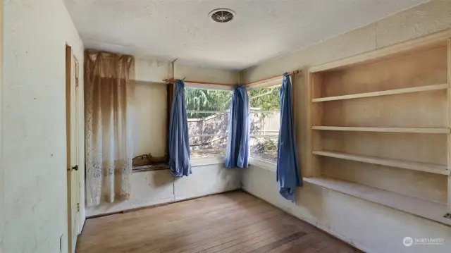 Bedroom with built-ins and more hardwood flooring ready to breathe new life.