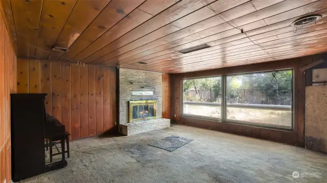 Spacious living room with fireplace just waiting to be brightened up and restored.