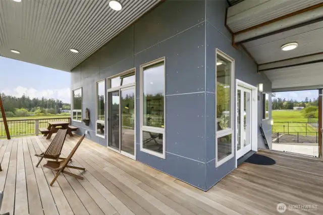 Covered wraparound deck with multiple seating areas—perfect for year-round enjoyment.
