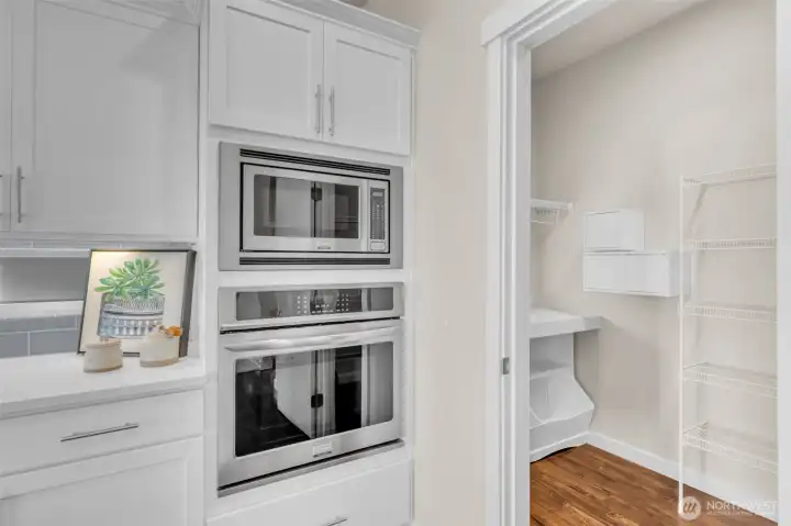 Wall oven & Build-in microwave off of the large walk-in pantry with built-in shelving.
