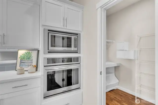 Wall oven & Build-in microwave off of the large walk-in pantry with built-in shelving.