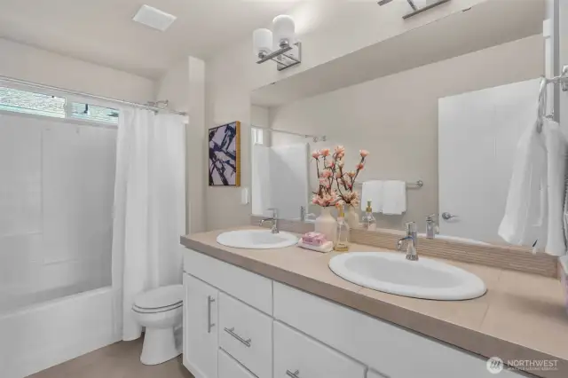 Upstairs bathroom with double sinks and full bath/shower.