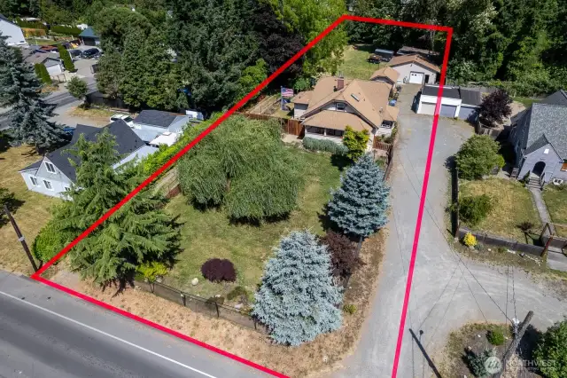 1+ acre Lot with two driveways, a detached shop/garage, 1 car detached garage, covered RV parking, shed, and so much more!!