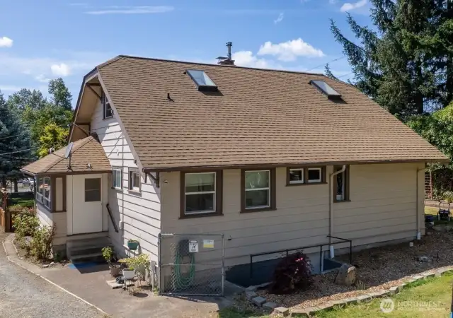 Side of home has covered porch/mud room entry into the kitchen area. Also note the exterior stairway/entry into the basement