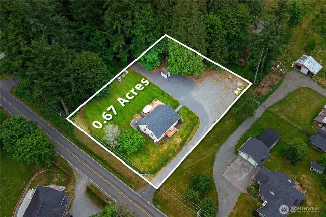 Aerial view clearly outlining the expansive 0.67-acre lot—offering privacy, room to expand, and a peaceful wooded backdrop, all within a well-maintained neighborhood.
