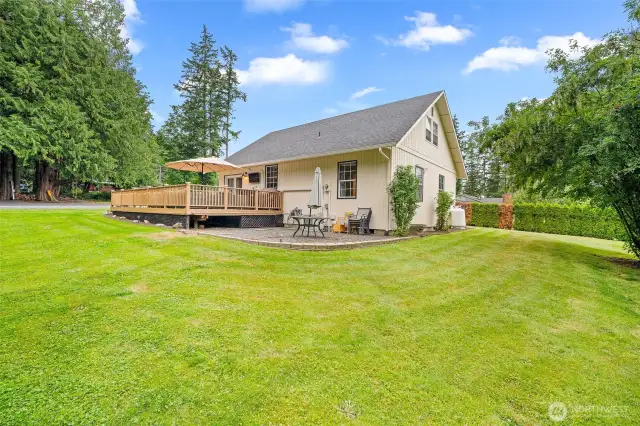 Spacious backyard retreat with mature landscaping, elevated entertainment deck—ideal for outdoor dining, relaxing, and enjoying the peaceful surroundings.
