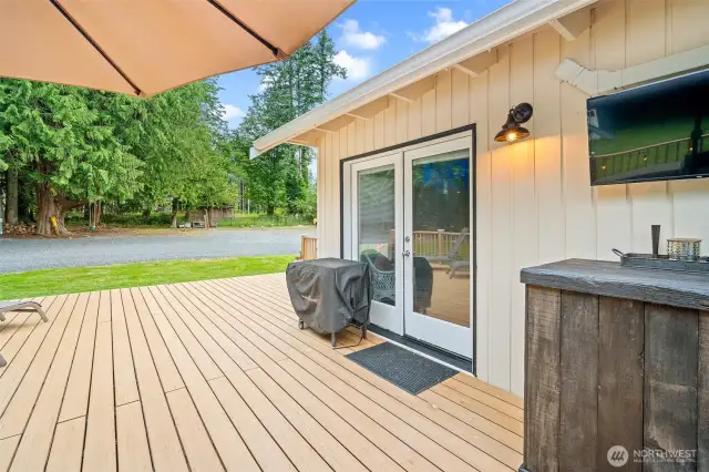 Step out through elegant French doors onto a spacious deck—perfect for grilling, relaxing under the trees, or catching the game