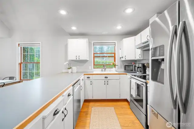 Bright and functional kitchen featuring ample counter space and a picture window over the sink overlooking the backyard.