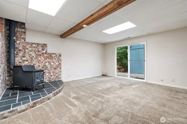 Downstairs family room with wood fireplace and sliding door access to backyard