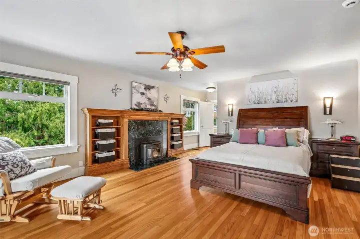 The primary bedroom on the main is a true retreat. Relax by the fireplace with built-in cabinetry, flawless wood floors and gorgeous original character of the home with coved ceilings.