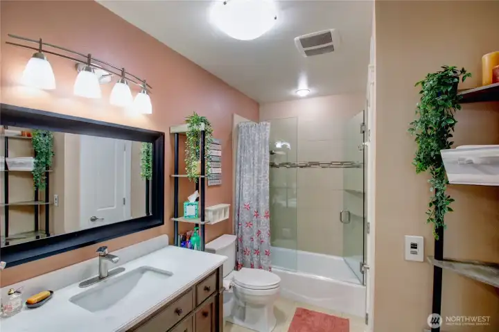 Full guest bath on main with tiled shower, radiant heated floors and storage closet.