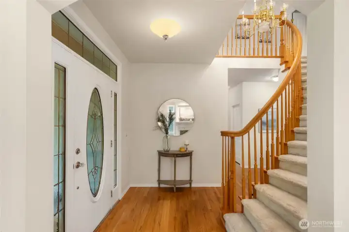 Entry with Hardwood Floors and Curved Staircase Detail