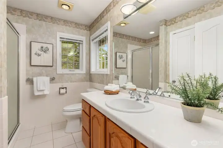 Spacious Guest Bathroom with Warm Wood Cabinetry and Tile Accents