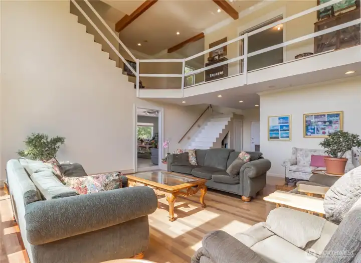 Living area with a view of the second-level walkway, highlighting the open and light-filled design throughout.