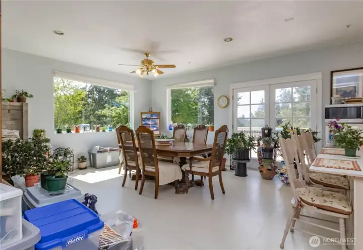 Open and light-filled dining area with French doors leading to one of the decks.
