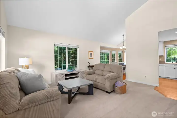 Sun-drenched and spacious! Vaulted ceilings and a wall of windows fill this main living space with incredible natural light, creating an open, airy atmosphere you’ll love coming home to.