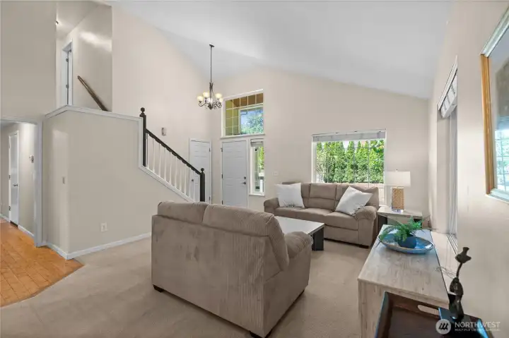 Towering vaulted ceilings give this living room a grand feel, while the abundant windows bring the beauty of the outdoors inside.