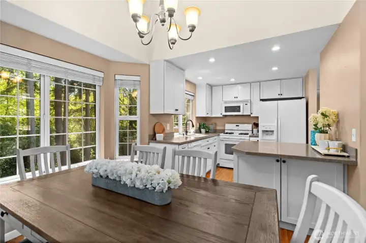 Bright, airy, and effortlessly connected. This open-concept view showcases a beautifully fluid layout, where natural light pours through the dining room windows to illuminate the entire heart of the home.