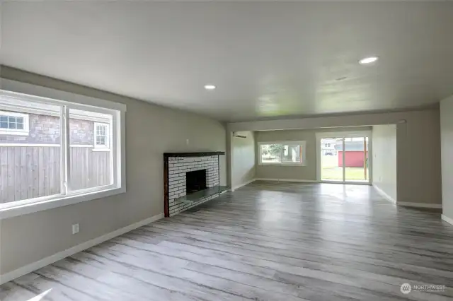 Main floor living room with wood fireplace and access to spacious patio.