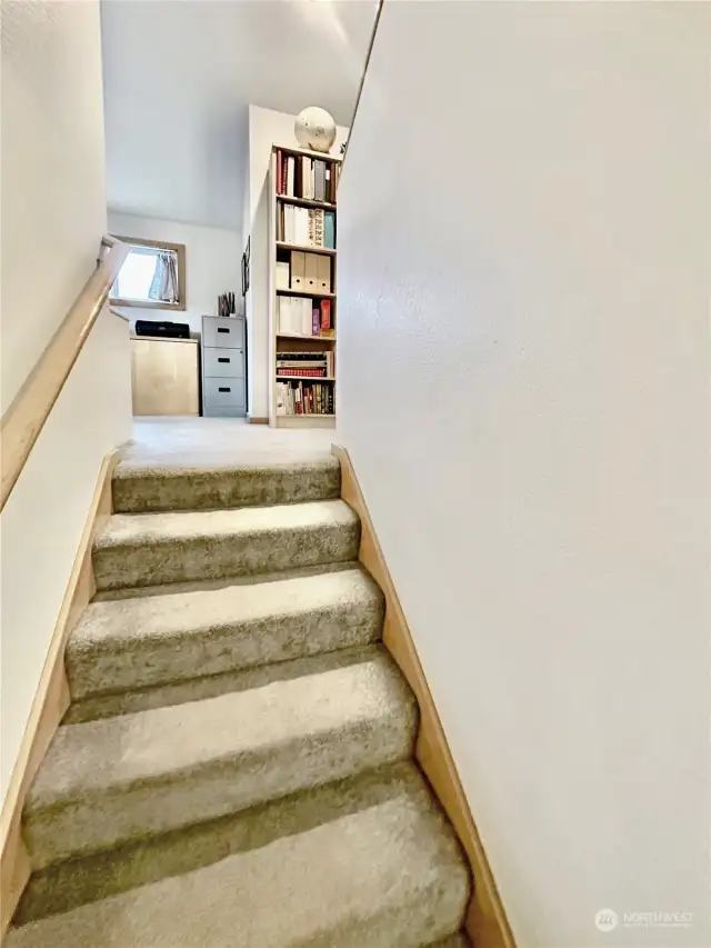 Stairs leading to end/office and additional bedrooms.