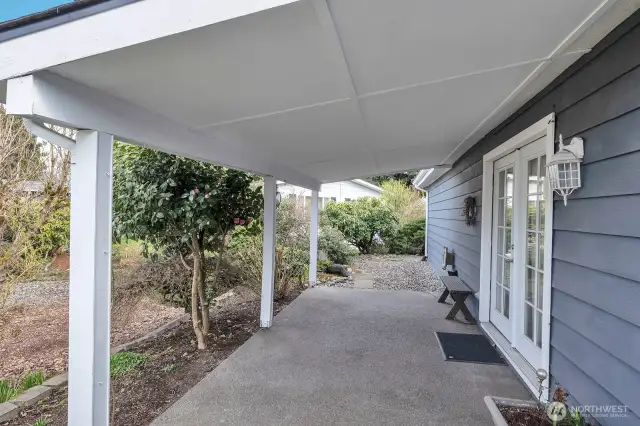 Covered patio area off the family room. Easy care shrubs, tree's and plants. Stone walkway to the back yard.