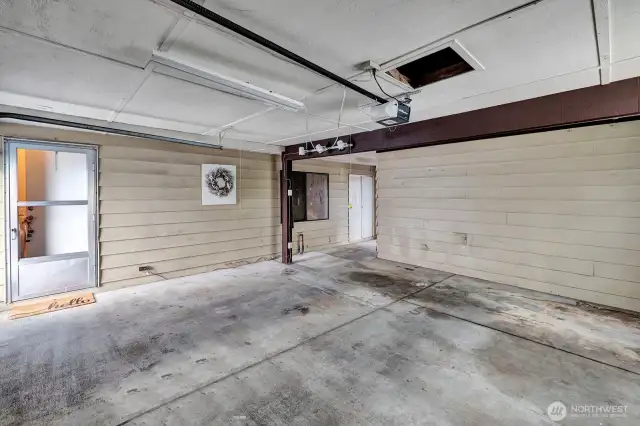 Inside view of the oversized 2 car garage. Access door from driveway into the garage along with the electronic garage door. Room for cars and toys!