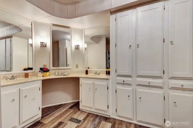 Primary bath has "Tons'" of cabinets for all your linens and bathing necessities. Double vanites  with a make up area.