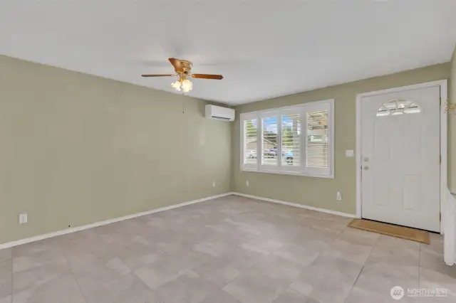 Living room with ceiling fan and mini split. Elegant faux wood shutter blinds.