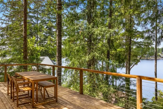 The expansive, elevated deck off the main residence offers tree-lined privacy and sweeping views.