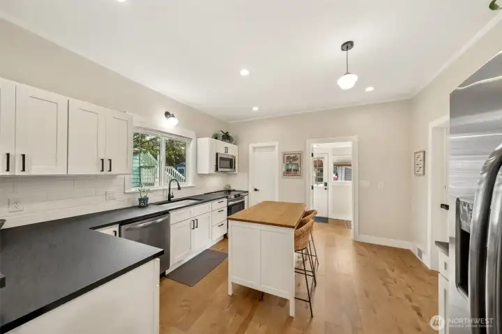 New stainless steel appliances, quartz countertops and walk-in pantry & laundry rom straight ahead leading out to backyard.