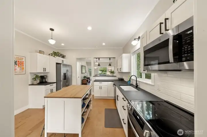 This fully remodeled kitchen is a showstopper! Crisp white shaker cabinets pair beautifully with a full tile backsplash for timeless style. Durable LVP flooring ties it all together, offering both elegance and easy maintenance.