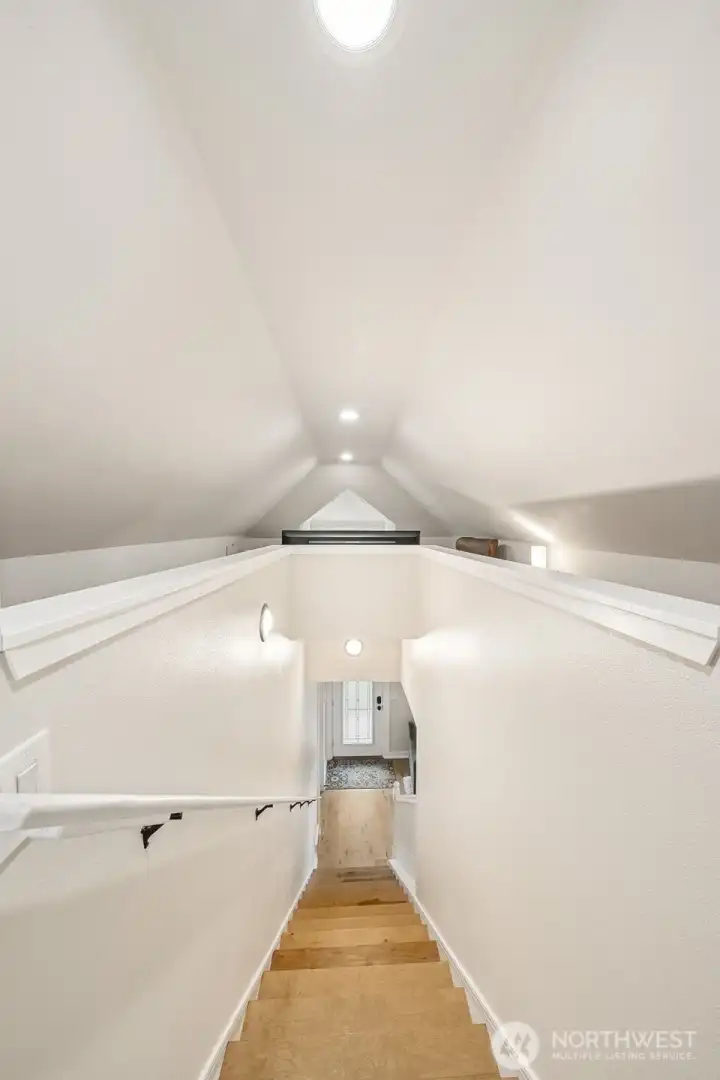 A stylish staircase leads to a versatile upstairs loft, perfect as a third bedroom, home office, or cozy retreat—flexible space to fit your lifestyle.