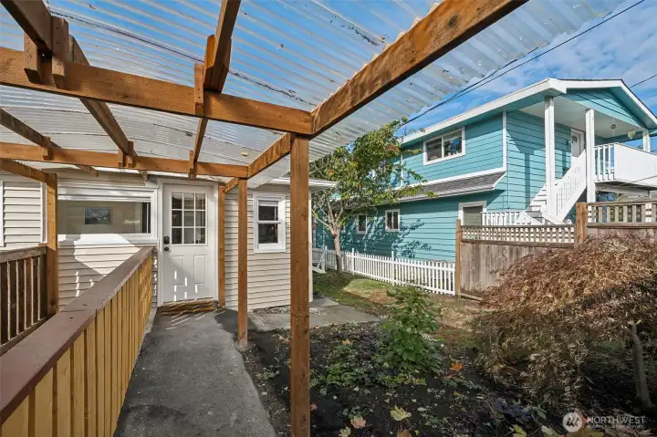 Just off the laundry room, a covered walkway leads to the detached garage—providing convenient, protected access in any weather. White picket fencing along the side yard with new gate.