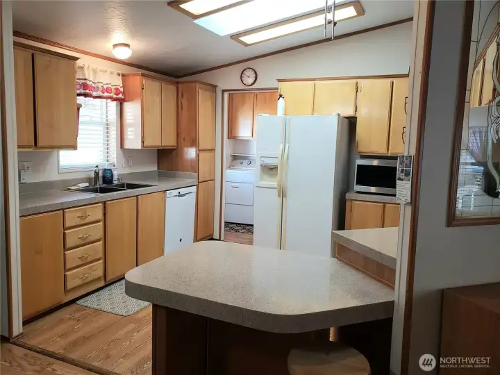 Nice Well Kept U Shaped Kitchen with Newer Appliances, Counter Tops, Laminate Flooring Showing Cathedral Ceilings and a Breakfast Eating Bar.