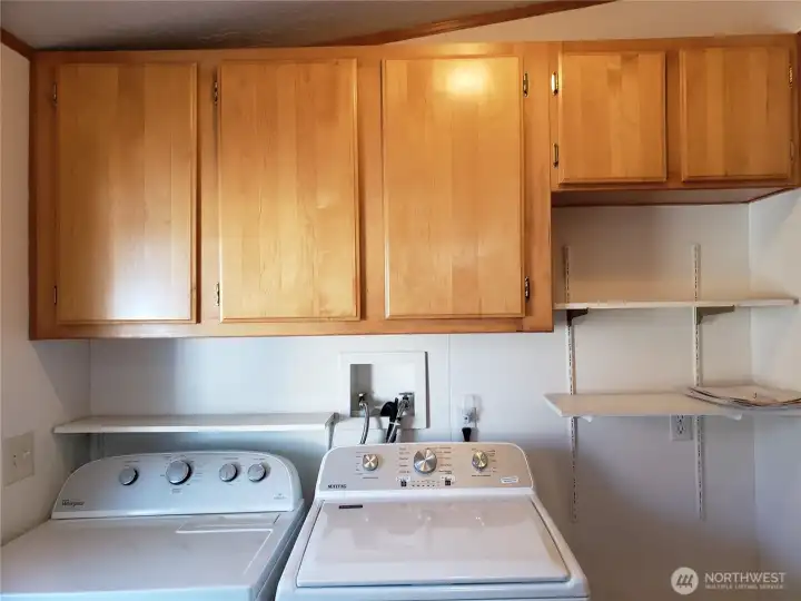 Another Picture of the Large Utility Room with Newer Washer, Dryer, 3 Shelves and 5 Storage Cabinets.