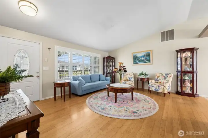 This charming rambler features a spacious living area with vaulted ceilings, large windows, and bamboo flooring.