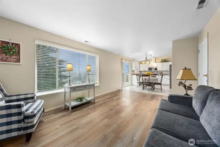 Large windows (with a view), LVP and continued vaulted ceilings extend through the family room.