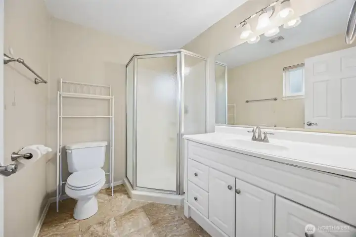 Attached 3/4 bathroom with white vanity and walk-in shower.