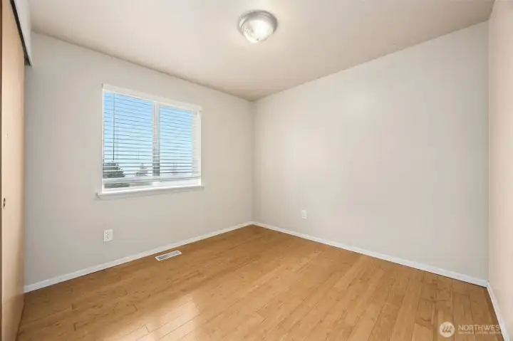 Bedroom #3 with continued bamboo flooring and white trim work.