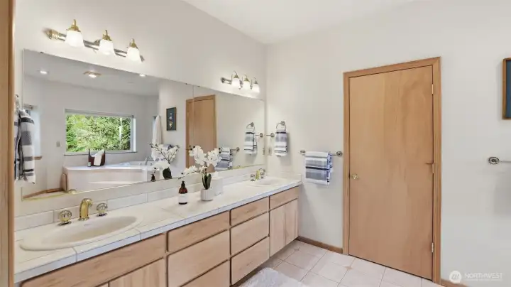Spacious primary ensuite featuring a dual-sink vanity with ample storage and bright, clean finishes