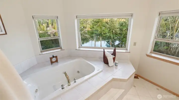 Unwind in the soaking tub surrounded by serene tree-lined scenery and tranquil lake views.