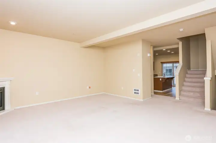 Left corner view of living room looking over to the kitchen, dining, and upstairs