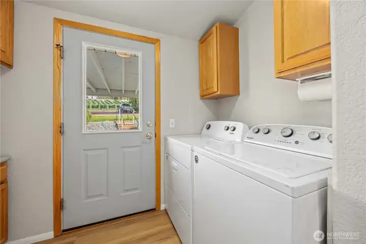 Laundry with door out to covered patio & garage