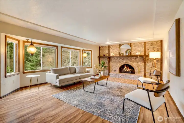 Large picture windows, warm hardwoods, and a brick wall center piece make this living room a place you'll want to enjoy.