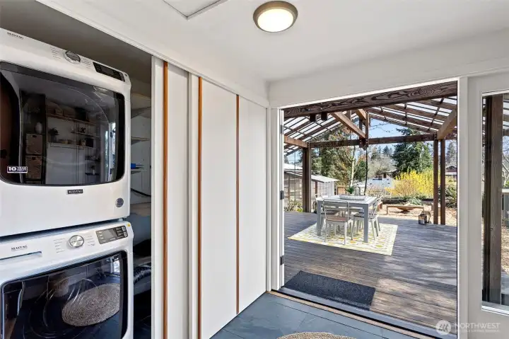 Washer/Dryer stack and custom closet doors next to french door exit to backyard