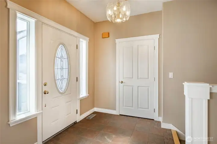 Entry with coat closet, staircase leading to lower level