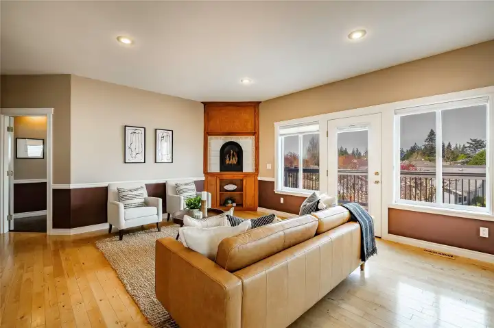 Living Room with gas FP and built-in custom shelving with access to deck.