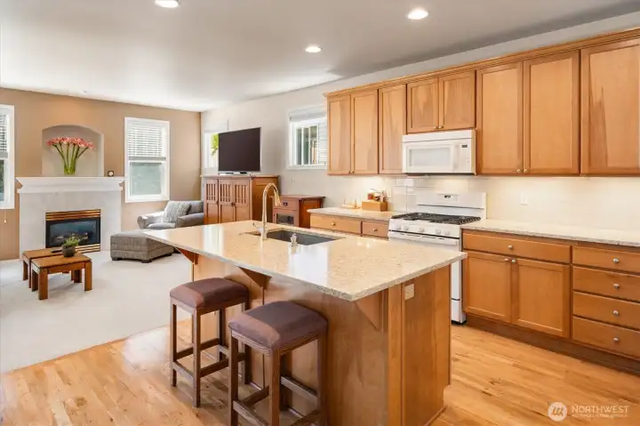 Bright, modern kitchen featuring quartz countertops, stylish backsplash, Blanco sink, and newer appliances (including 2023 range).