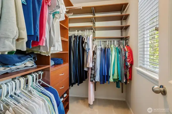 Primary bedroom walk-in closet with custom organizers.