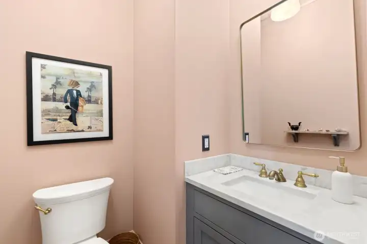 Main floor powder room with marble counter tops and vintage lighting. All wiring and plumbing throughout the home is new. Main floor powder room with marble counter tops and vintage lighting. All wiring and plumbing throughout the home is new.